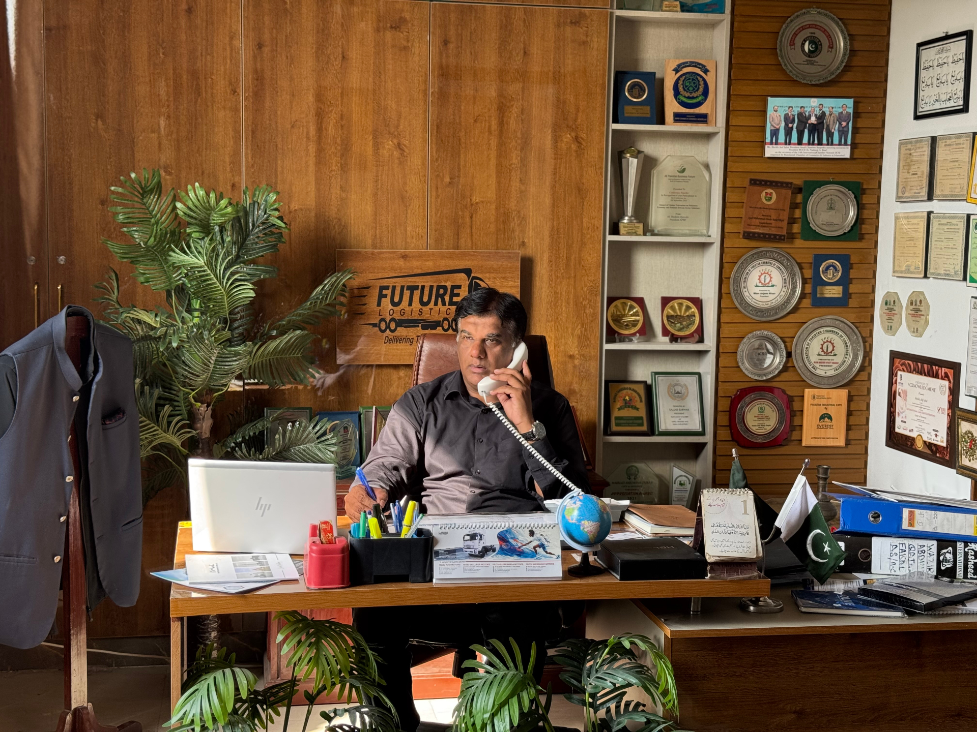 Future Logistics proprietor at the Lahore head office with branded signage and awards